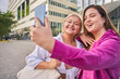 Body positive millennial women holding smartphone and making selfie
