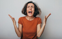 Close Up Shot Of Screaming Crazy Frustrated Woman With Anxiety, Anger And Depression. Very Upset And Emotional Woman Crying. Young Girl With Angry And Furious Face. Human Expressions And Emotions