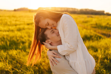 Wall Mural - portrait of smiling young couple in love standing gentle hugging with closed eyes on beautiful green