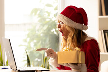Woman At Home With Santa Claus Hat And Computer With Surprised Expression