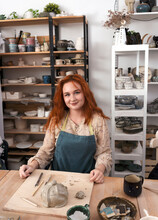Young Attractive Red Head Potter At The Ceramic Studio. Professional Ceramist Sculpts From Clay.
