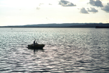 Wall Mural - Man in a fishing boat silhouette