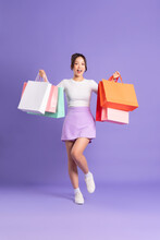 Young Asian Woman Holding Shopping Bag On Purple Background