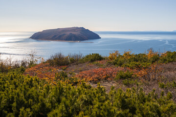 Wall Mural - Beautiful autumn landscape. View from the high coast to the sea and the island. Nedorazumeniya Island, Taui Bay, Sea of Okhotsk. Nature of the Magadan region and Siberia. Far East of Russia.