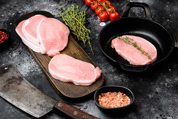 Wall Mural - Fresh pork, on frying cast iron pan, on black dark stone table background