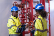 © amorn - Two engineer or technician maintenance, checking, or test system springer prevent fire. Group of African American contractor checking fire sprinkler system, pipe assembly, red fire pipe
