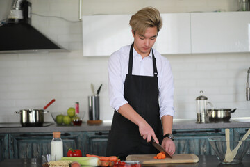 Asian cook in the kitchen prepares food in a cook suit