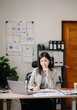 © Nuttapong punna - Asian businesswoman working in the office with working notepad, tablet and laptop documents .