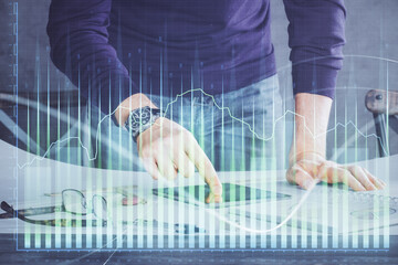 Poster - Double exposure of man's hands holding and using a digital device and forex graph drawing. Financial market concept.