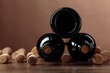 Bottles of red wine and wine corks on a wooden table.