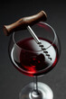 Glass of red wine and corkscrew.
