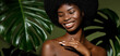 © Beauty Agent Studio - Green beauty portrait. Young African American woman posing agaings tropical green leaf. Natural cosmetics concept.
