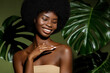 © Beauty Agent Studio - Green beauty portrait. Young African American woman posing agaings tropical green leaf. Natural cosmetics concept.