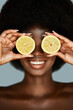 © Beauty Agent Studio - Vitamin C. Overjoyed african american model holding lemons on her eyes. Natural organic cosmetic concept