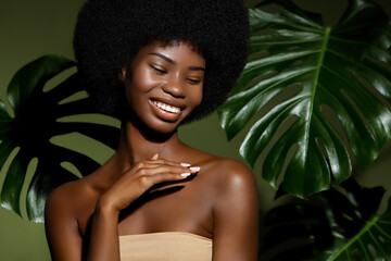 Wall Mural - green beauty portrait. young african american woman posing agaings tropical green leaf. natural cosm