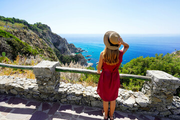 Wall Mural - Vacation in Italy. Full body of young woman with hat in Capo Vaticano on the Coast of the Gods, Calabria, Italy.