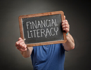 financial literacy white chalk on a blackboard held by a teacher, mentor or presenter, the ability to understand and effectively use personal financial management, budgeting, and investing
