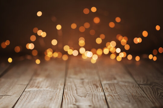 Fototapete - Christmas Bokeh Background -  Magic golden blurred lights on brown rustic wood - Backdrop for product presentation