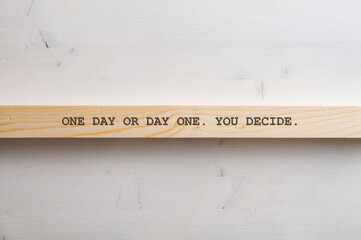 One day or day one. You decide. sign written on a wooden slat