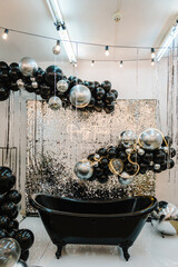 Wall Mural - Happy New Year 2023. Black and silver decor. Bath for photography. Place for congratulations on birthday. Arch, photo booth decorated balloons and bulbs. Zone, wall with sparkling sequins for wedding.