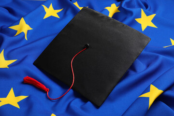 Wall Mural - Black graduation cap on flag of European Union