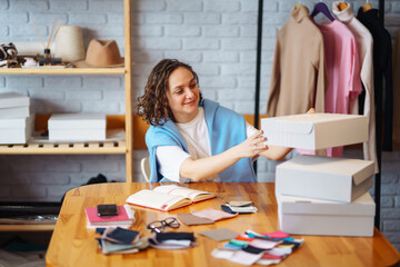 Wall Mural - Small business owner, entrepreneur, seller  checking ecommerce clothing store orders  working in her office. Online sales.