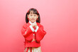 Chinese young girl  with traditional  dress with  gesture of happy new year congratulation isolated on pink background.