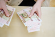 © andrey - a woman holds in her hands and recalculates Russian banknotes of 100 rubles.