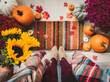 © Cavan Images - Top view of woman standing in doorway surrounded by fall decor.