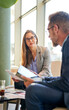 © Cavan Images - Two colleagues sitting in a cafe, having an informal business meeting