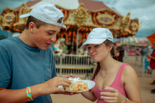 Two Happy Teens Sharing A Funnel Cake At A Fair