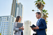 © Cavan Images - Business man and woman coworkers in front of office building