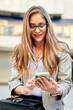 © Cavan Images - portrait of smiling businesswoman telephoning in front of skyline