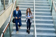 © Cavan Images - Business colleagues walking down stairs outdoors