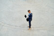 © Cavan Images - businessman working with computer in front of office building