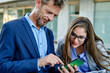 © Cavan Images - Group of smiling business people in a meeting together outdoors.