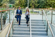 © Cavan Images - Business colleagues walking down stairs outdoors