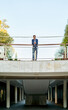 © Cavan Images - caucasian businessman standing in front of a corporate building