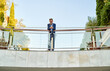 © Cavan Images - caucasian businessman standing in front of a corporate building
