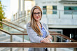© Cavan Images - caucasian businesswoman standing in front of a corporate building