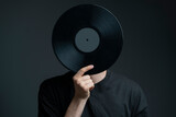 Fototapeta  - holding a vinyl record disc in front of head