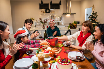 Multi-ethnic family exchanging presents during Christmas party at home