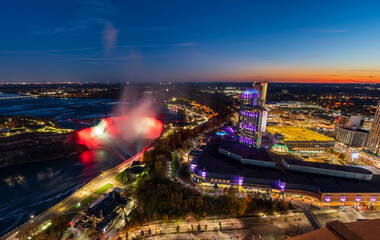 Wall Mural - Aerial view of Horseshoe Falls in twilight time. Niagara Falls City downtown illumination. Stunning landscape at night.