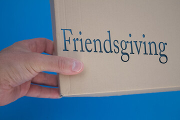 Poster - Friendsgiving word with cardboard box. Brown folded card box.
