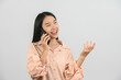 © Johnstocker - Protrait of Young asian woman talking on mobile phone while standing isolated over white background