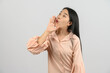 © Johnstocker - Portrait of Excited young asian woman in pink shirt shout story or making announcement over isolated white background