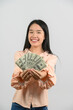 © Johnstocker - Portrait of a cheerful young woman holding money banknotes and celebrating isolated over white background