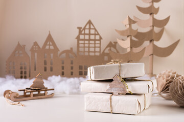 DIY Christmas home decor - a stack of gifts in craft paper, a cardboard tree and a house. Handmade