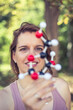 © Westend61 - Smiling woman examining molecule model in park