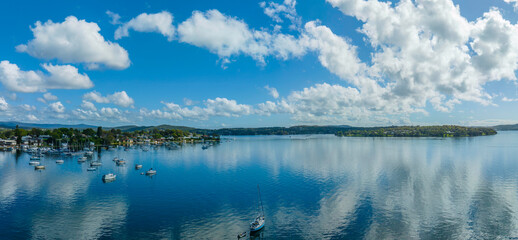 Morning waterfront views with clouds, boats and the blue lake water.